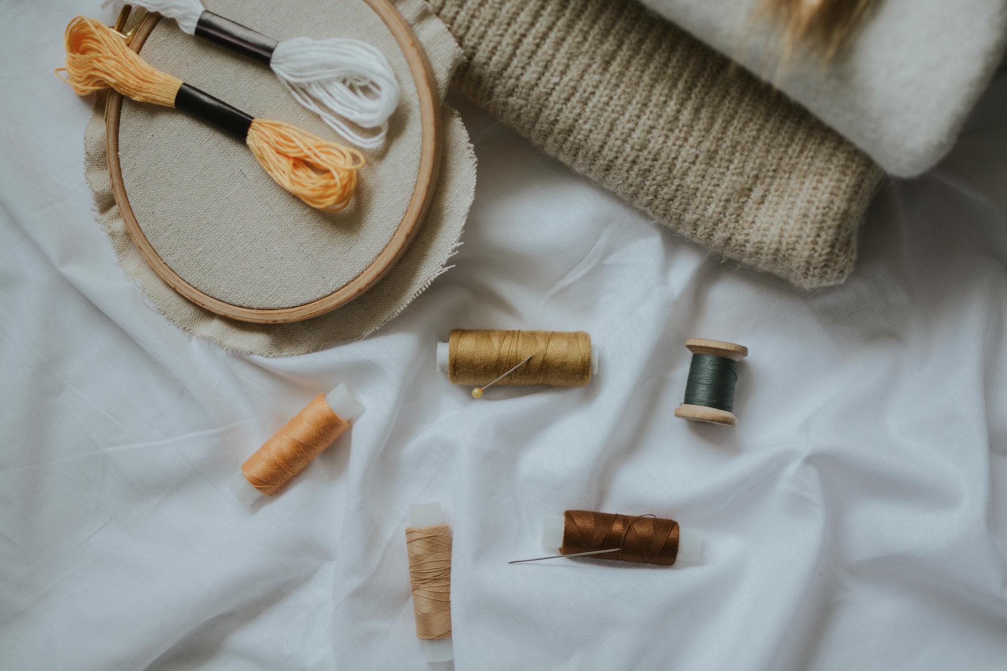 Workspace with threads and an embroidery sampler